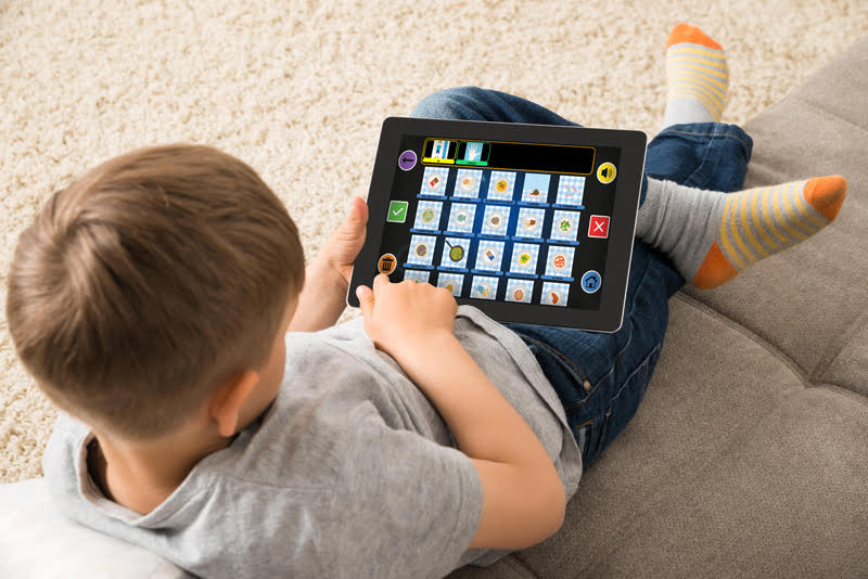Bambino con autismo che utilizza app specializzata su tablet per la comunicazione